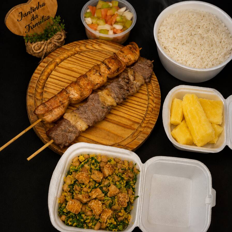 Combo completo e bem servido para matar a fome de verdade! Acompanha 1 marmitex de arroz soltinho, 1 hamburgueira de feijão tropeiro bem temperado, 1 mandioca mini, 1 copo pequeno de vinagrete fresquinho e 2 espetinhos saborosos: contra-filé e frango com bacon. Serve 2 pessoas Acompanha 2 espetinhos: contra-filé e frango com bacon Combo completo, ideal para quem quer uma jantinha reforçada.