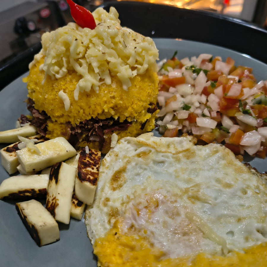 Cuscuz recheado com carne seca, queijo coalho grelhado, ovo frito e vinagrete