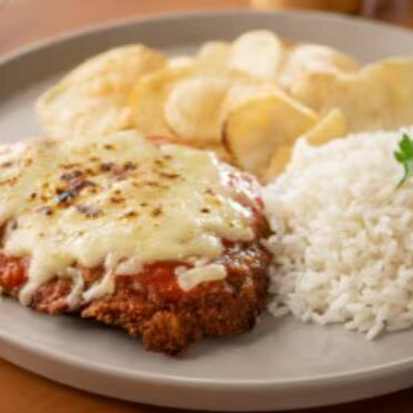 Prepare-se para a melhor Parmegiana da sua vida! Feita com nosso exclusivo molho de tomate artesanal — sem conservantes, sem água e longe dos molhos prontos. Usamos apenas queijos de altíssima qualidade para garantir o sabor perfeito.  Acompanha arroz branco soltinho e batata chips super crocante. Tudo isso embalado separadinho, do jeitinho que você merece. Uma combinação tão deliciosa que dá vontade de rezar a cada garfada! Essa opção é acompanhada de arroz branco e batata chips super Crocante.