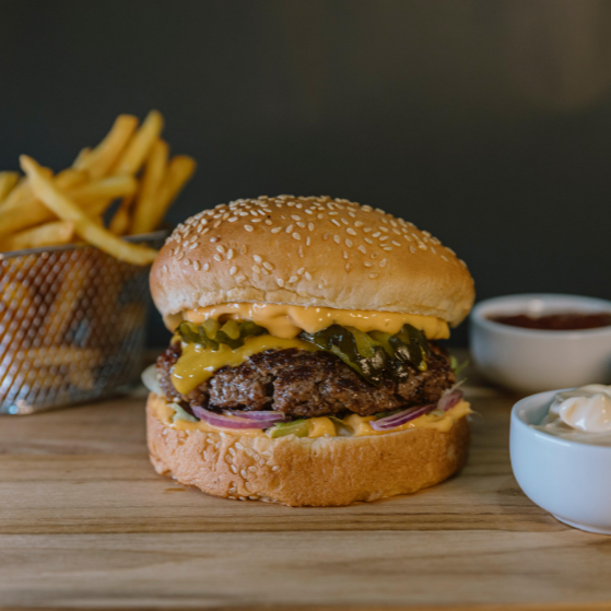 Pão tradicional com gergelim, hamburguer artesanal 110gr, molho especial, alface americana, cebola roxa, picles e cheddar