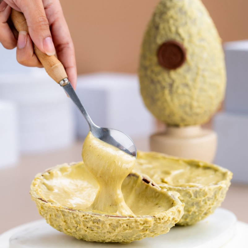 Casca de chocolate de pistache recheada com Nhá Benta suave de pistache, aveludada e aromática, com o sabor refinado e marcante do pistache. Aprox. 500g