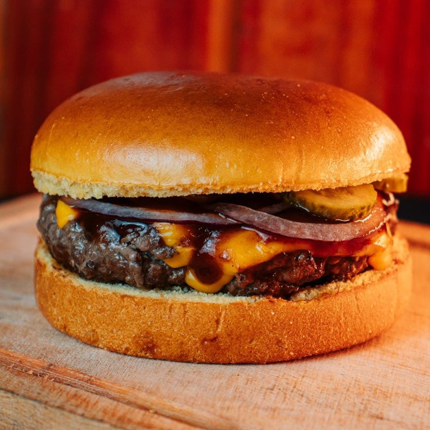Smash Burger de 100g com cheddar, picles, cebola roxa e molho barbecue no pão de brioche: uma explosão de sabores em cada mordida, com ingredientes frescos e irresistíveis.