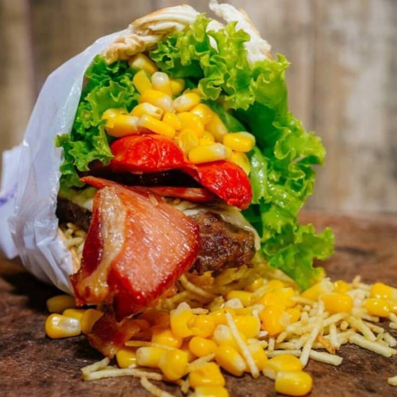 Hambúrguer perfeito com ingredientes irresistíveis: pão com gergelim, queijo derretido, presunto suculento, bacon crocante, ovo, alface fresca, tomate suculento, milho e finalizado com batata palha. Seu desejo, seu hambúrguer. Peça agora e saboreie!