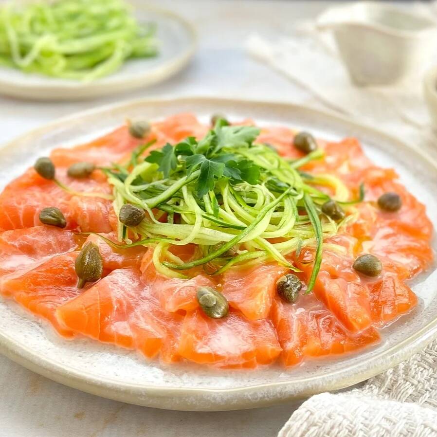 Delicadas lâminas de salmão fresco, servidas com azeite extravirgem, limão, sal, pimenta-do-reino e ervas frescas. Uma entrada leve, refrescante e sofisticada.