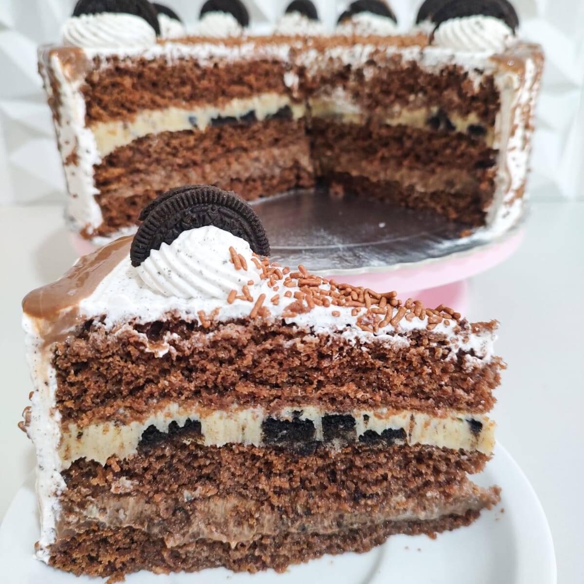 Fatia de Torta de Oreo: massa de chocolate fofinha, brigadeiro branco com pedaços de Oreo e brigadeiro tradicional super cremoso. Uma combinação intensa, geladinha e irresistível para quem ama chocolate e não abre mão de uma sobremesa de verdade.