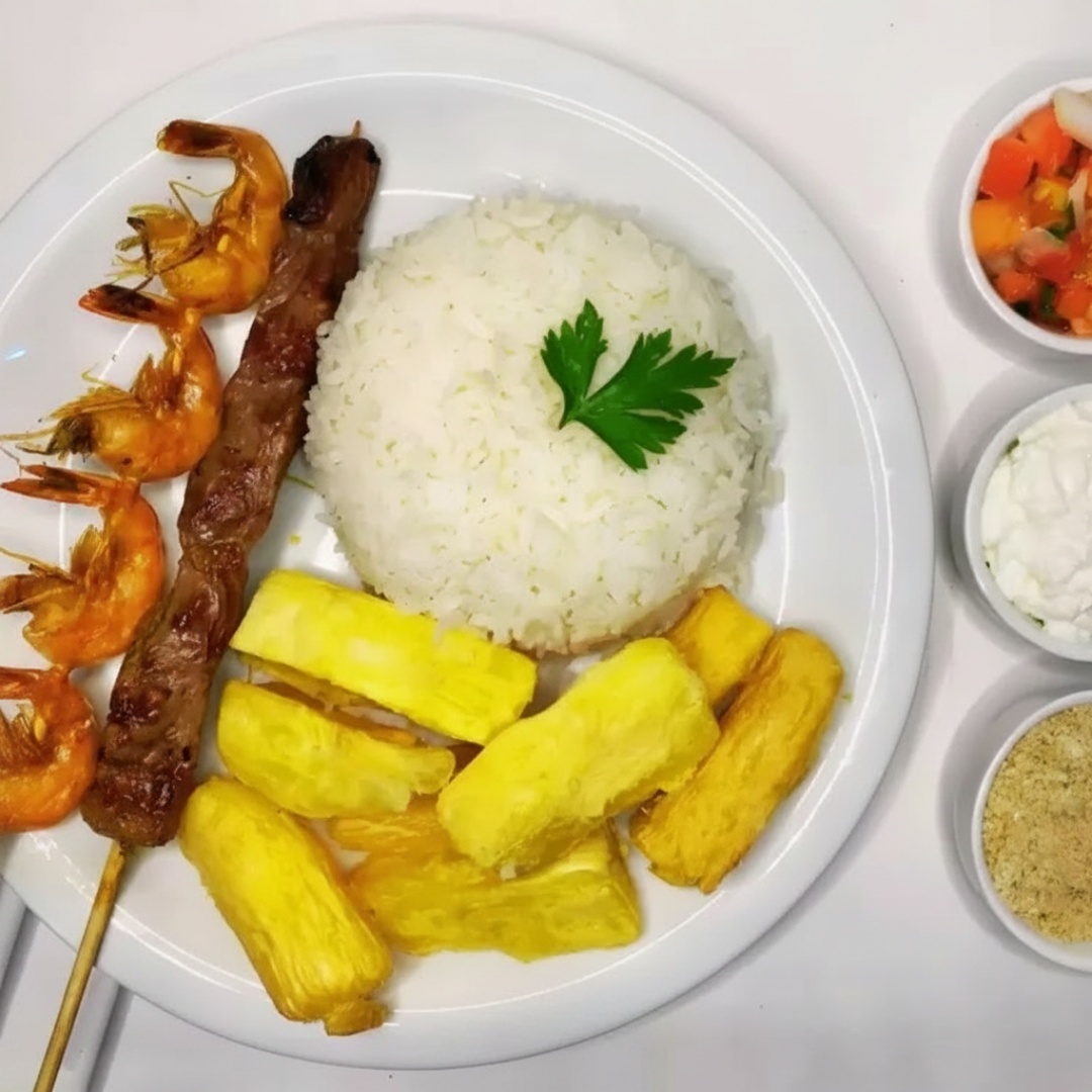 A Jantinha Completa que você monta! Delicie-se com uma base clássica e irresistível de Arroz Soltinho, Farofinha, Vinagrete Fresco e Molho de Alho da Casa, e finalize escolhendo 2 Espetinhos e 1 Mini Porção que mais te agradam!