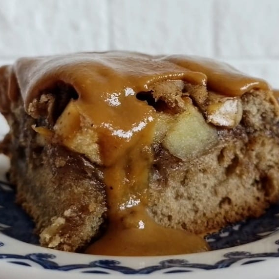 Delicioso bolo com pedaços de maçã, adoçado com açúcar mascavo e uma cobertura de doce leite de castanha de caju