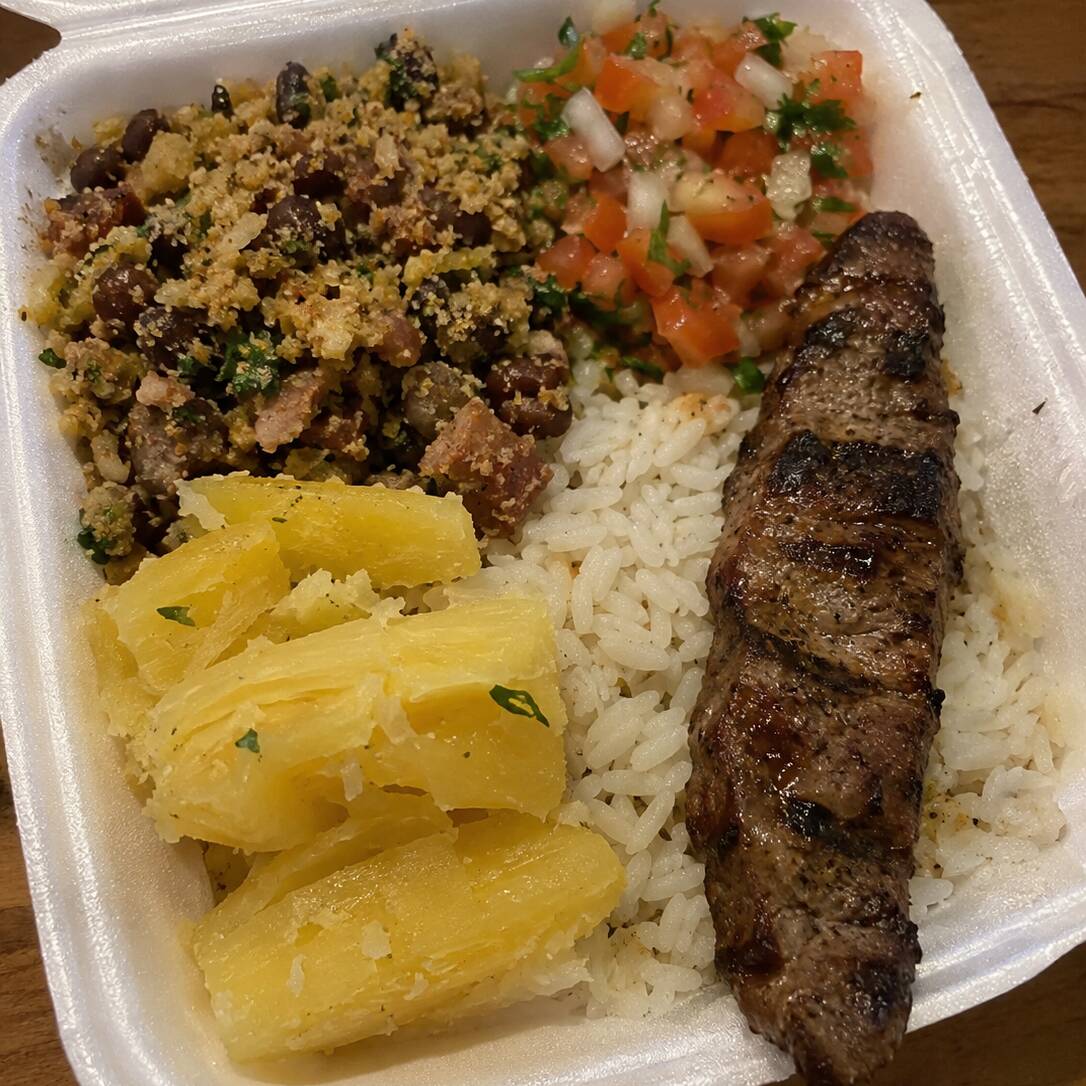 Arroz, vinagrete, mandioca e feijão tropeiro, acompanhados de 1 espetinho à sua escolha (asinha, coração, linguiça ou carne), servido na marmita.