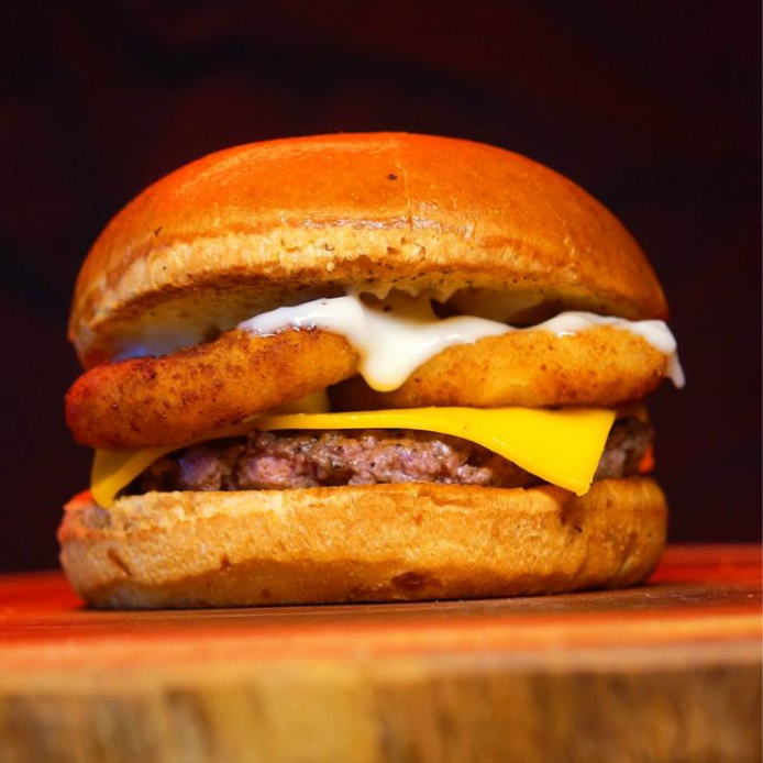 Hambúrguer 80g, onions rings, queijo cheddar barbecue e maionese burger grill num pão amanteigado.