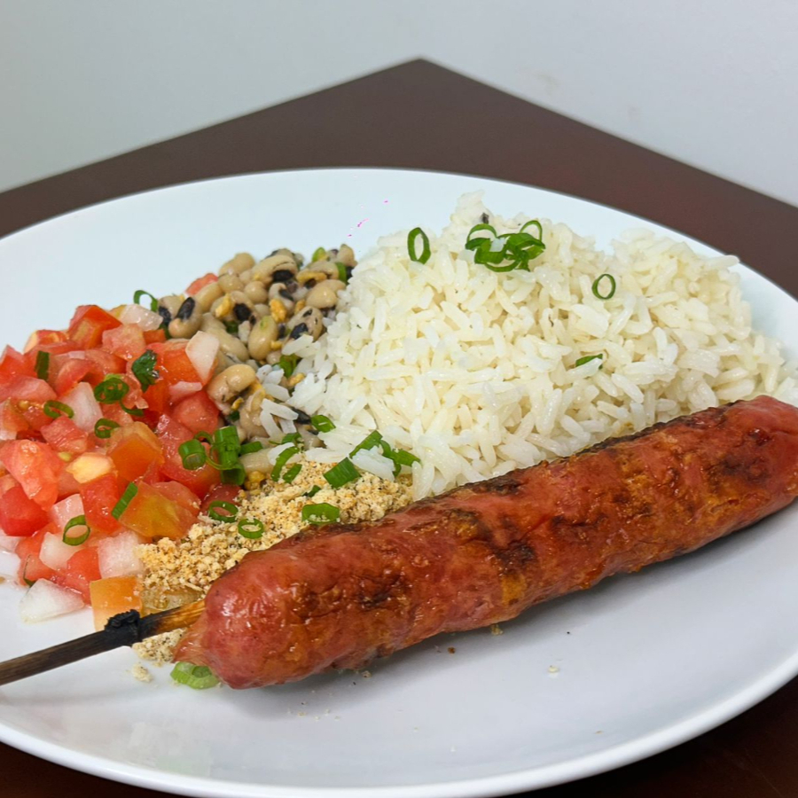Deliciosa combinação contendo um espeto de linguiça toscana acompanhado de arroz, feijão fradinho, vinagrete e farofa.