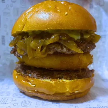 Pão de Brioche, 2 Hambúrgueres (120g), Mussarela Empanada, Cebola caramelizada, maionese verde da casa.