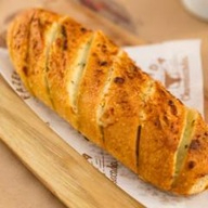 Pão baguete recheado com creme de alho, parmesão, assado em nosso forno.