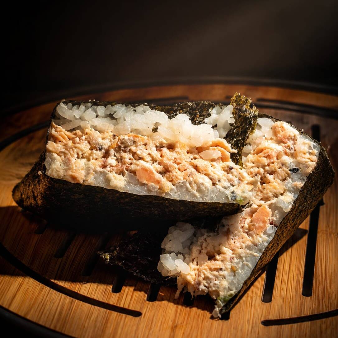 Nosso onigiri de salmão com muito mais proteína e menos carboidrato. Salmão grelhado, cream cheese, cebolinha, gergelim, arroz japonês, alga nori. Nossa Linha PRO tem mais que o dobro de proteína que o onigiri tradicional.