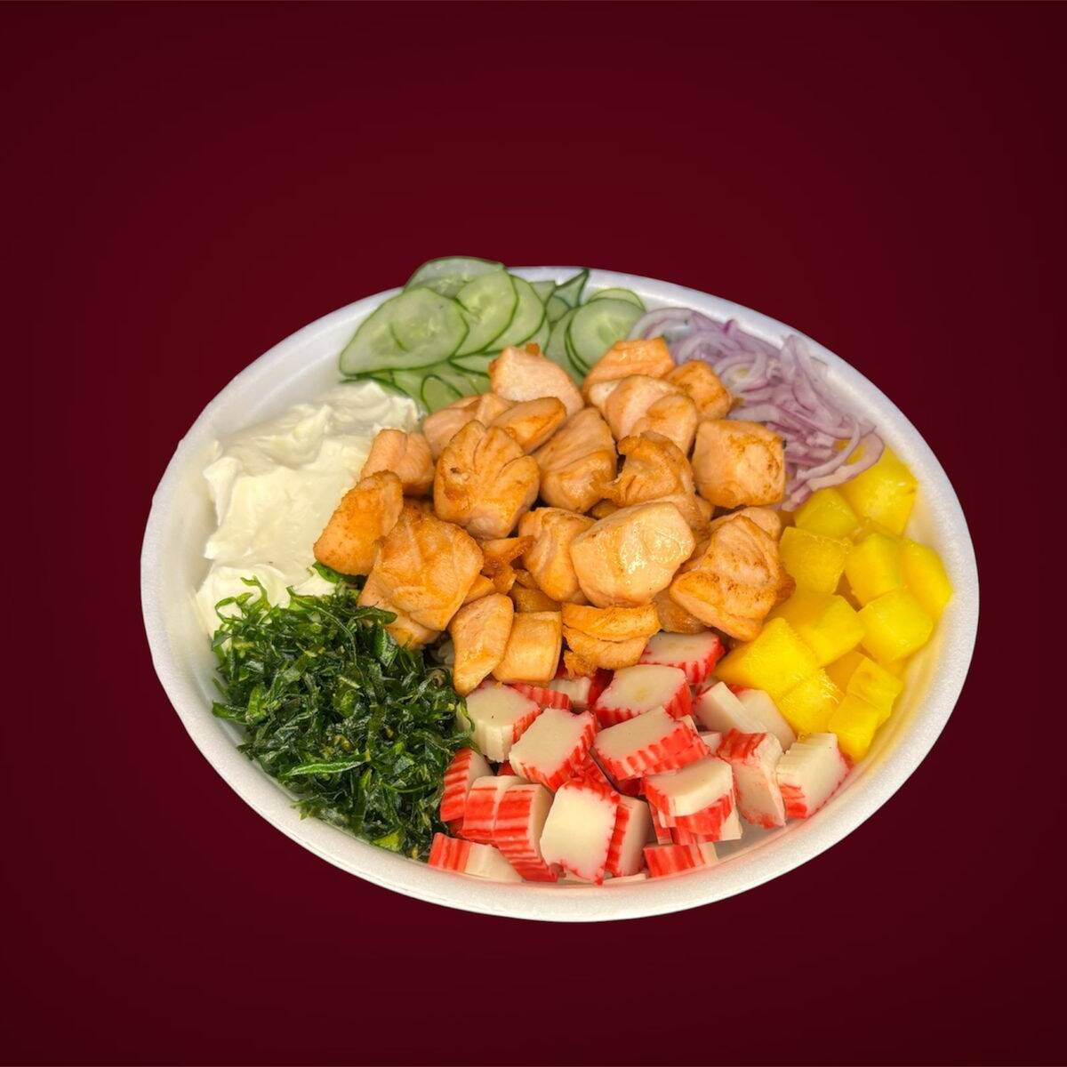 Poke saboroso com salmão em cubos grelhados , manga, pepino, kani, cebola roxa cream cheese e couve . Base de arroz japonês