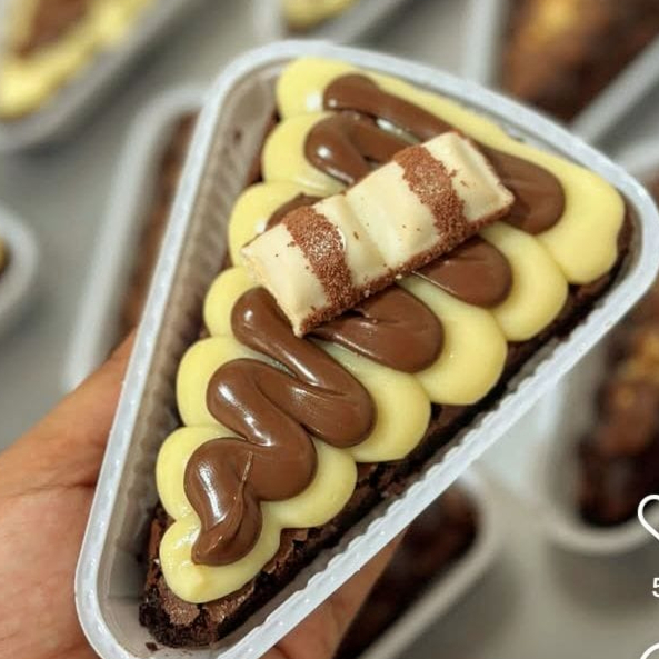 Deliciosa fatia do nosso nosso brownie suculento e casquinha crocante e finalizados com brigadeiros gourmet de ninho com Nutella.