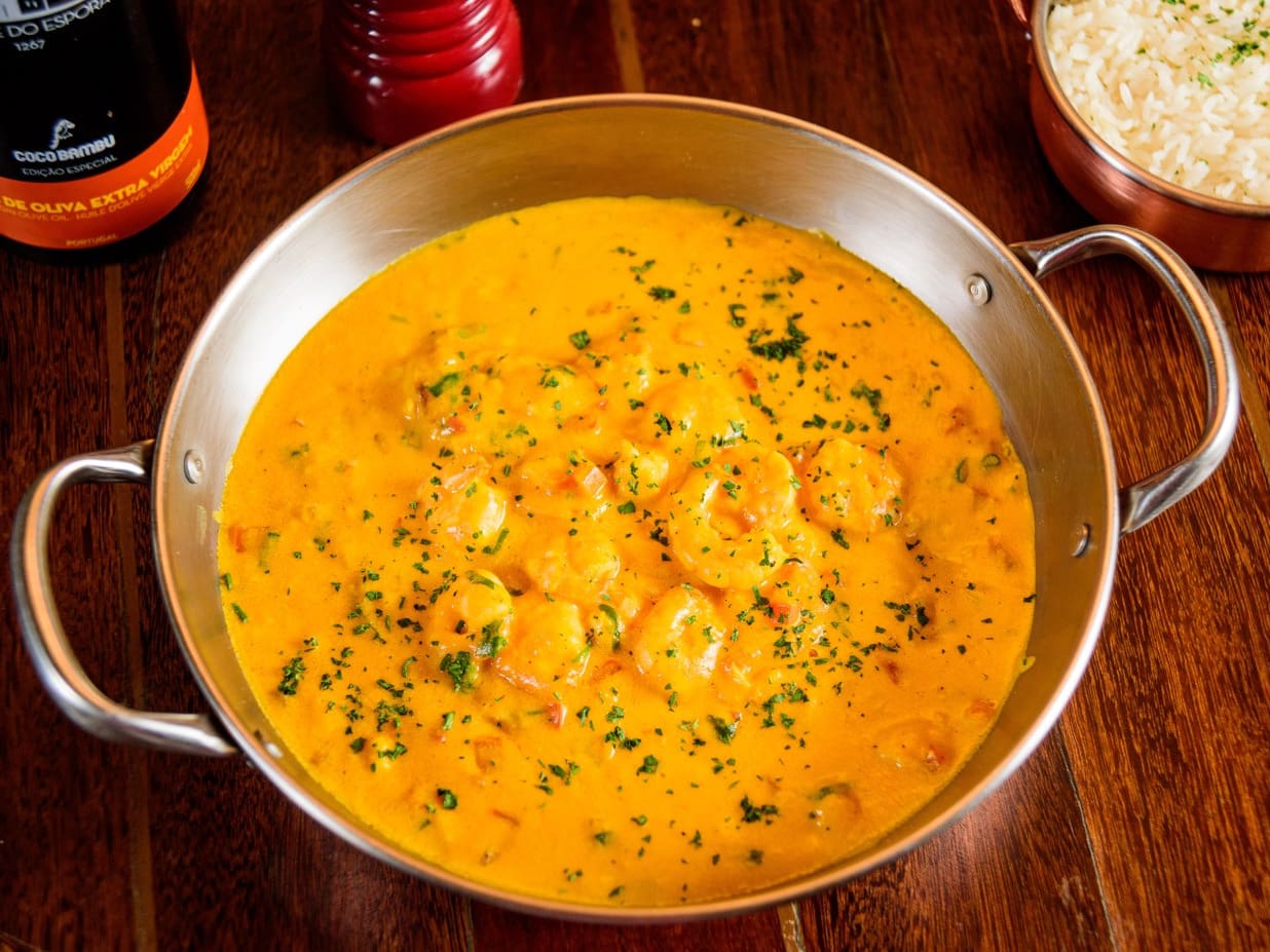 Filé de peixe grelhado e coberto com molho de camarão, com tomate, pimentões, cheiro verde e leite de coco. Acompanha arroz branco.