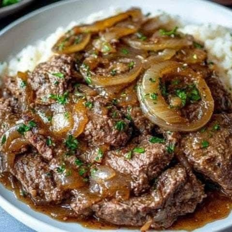 Bife refogado com cebolas em rodelas, acompanhado de arroz, macarrão, feijão, salada e farofa.