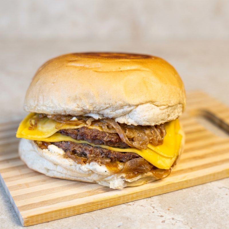 Pão de hambúrguer, 2 hambúrguer artesanal, 2 Fatias de queijo prato, molho verde, barbecue .