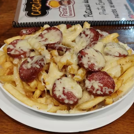 Deliciosa porção de fritas com calabresa fatiada e queijo mussarela gratinado no maçarico.