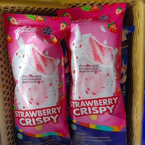 Uma unidade de sorvete sabor baunilha e morango coberto com chocolate branco e pedaços de biscoito red velvet