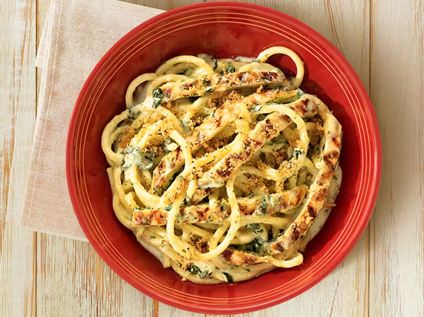 Bucatini ao molho Alfredo com espinafre, acompanhado de frango grelhado e finalizado com farofa especial da casa.