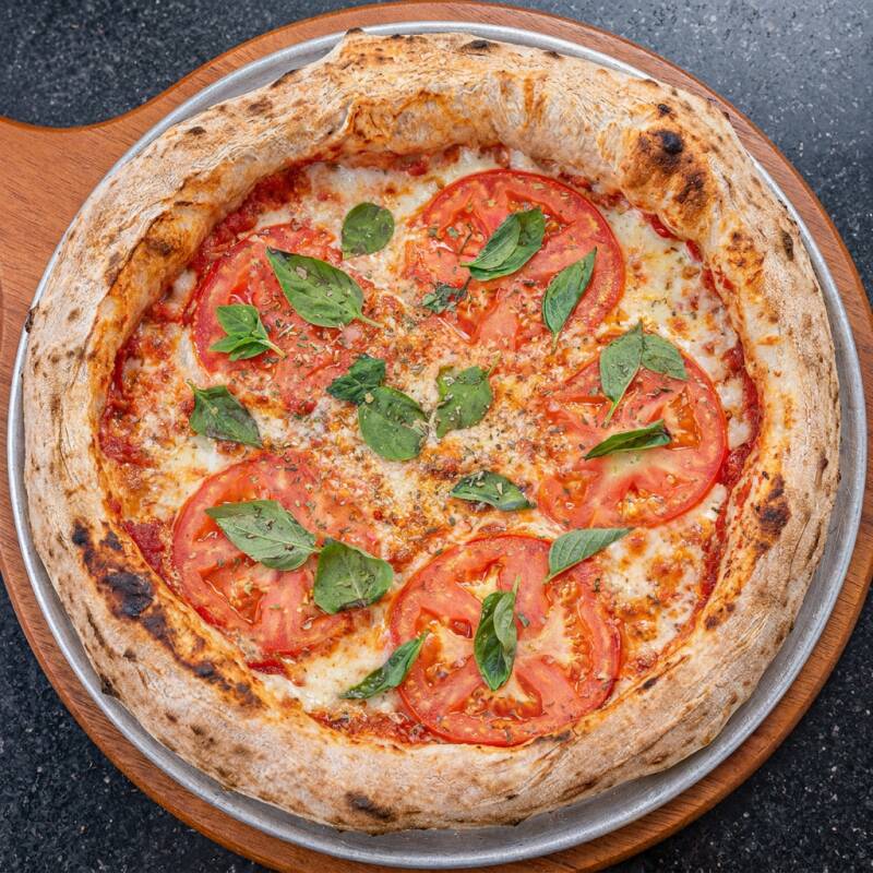 Muçarela Derretida, Tomate Fresco, Parmesão Finalizando e Manjericão Aromático, Com Massa Maturada Crocante. Clássica, Leve e Cheia de Sabor