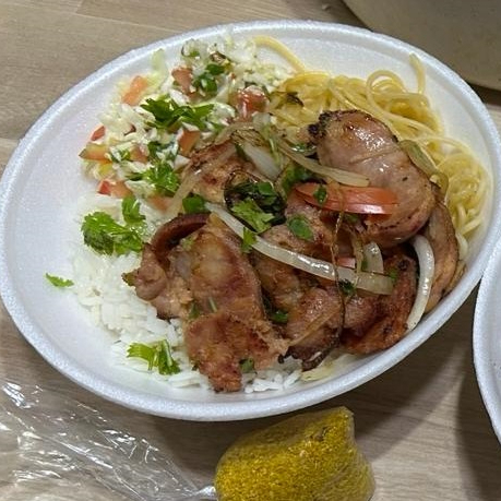 Linguiça toscana grelhada com arroz branco, macarrão, feijão caseiro, farofa temperada, cebola e vinagrete fresco.