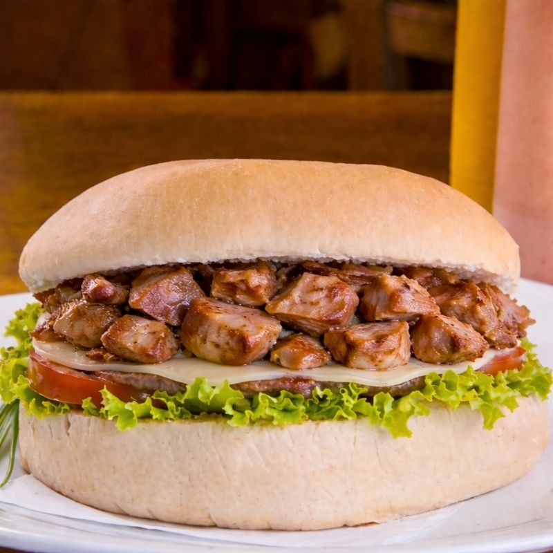 Pão gourmet, pernil , hambúrguer artesanal de 120 gramas, queijo, presunto, milho, ervilha, tomate, alface e maionese caseira