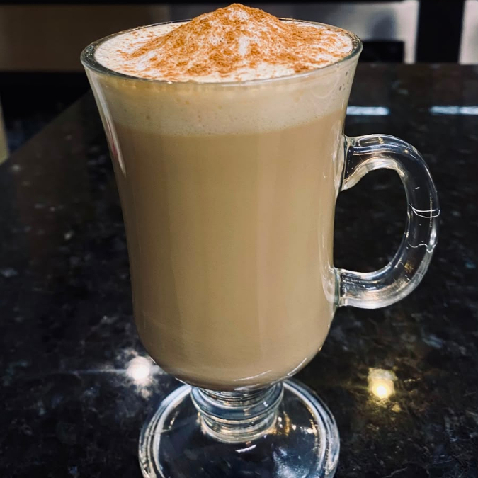 Um shot de café espresso, leite vaporizado, finalizado com canela.