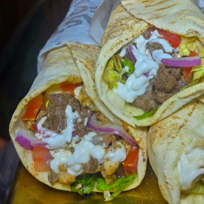 Pão sírio, iscas de carne e frango bem temperado e macio, tomate, alface, cebola roxa e um delicioso molho de alho artesanal.
