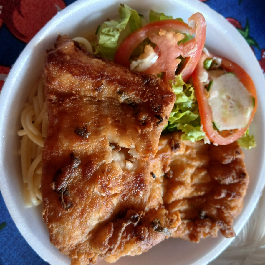 O prato é acompanhado por uma porção de arroz, feijão, macarrão, salada e farofa.