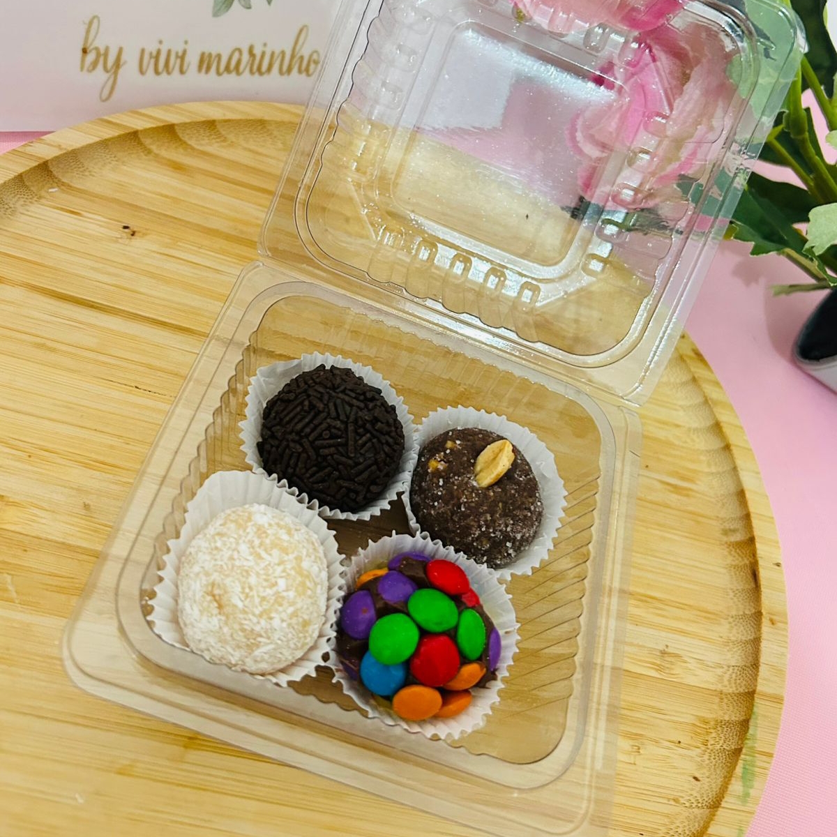 um docinho de chocolate com confetes, um beijinho, um cajuzinho e um brigadeiro, gramatura entre 20g a 22g