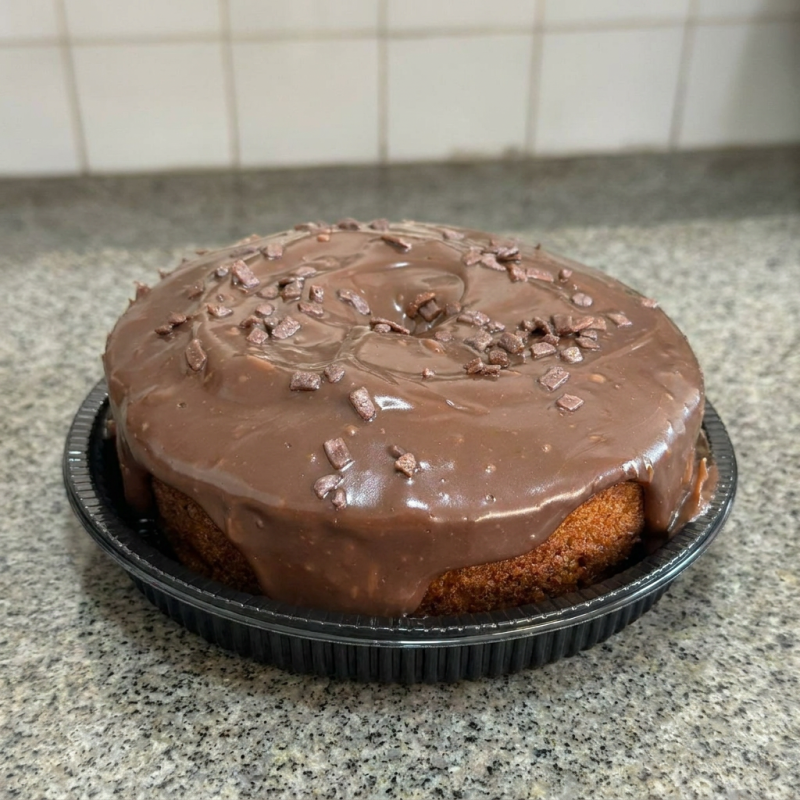 Delicioso bolo de cenoura com cobertura de brigadeiro ao leite, com sabor de infância, perfeito pra qualquer momento do seu dia. Aproximadamente 500g.