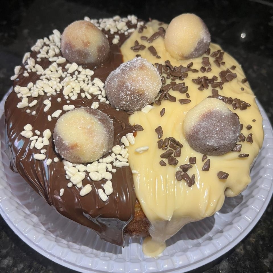 Massa mesclada, recheada com brigadeiro de chocolate cremoso, brigadeiro branco cremoso, finalizado com granulado preto, branco e doce casadinho.