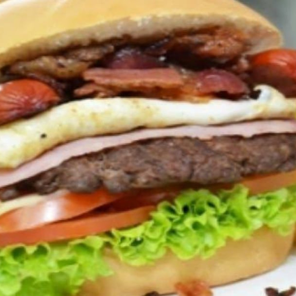 Pão macio, 1 hambúrguer artesanal com pedaços de calabresa picada , milho, calabresa, frango desfiado, chedder, catupiry muçarela derretida, , presunto, ovo, alface, tomate e nossa maionese especial.