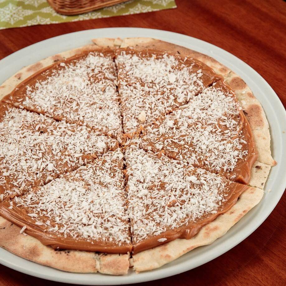 Pizza doce de leite com coco ralado, cremosa e com sabor caseiro irresistível. Combinação perfeita de doçura e textura!