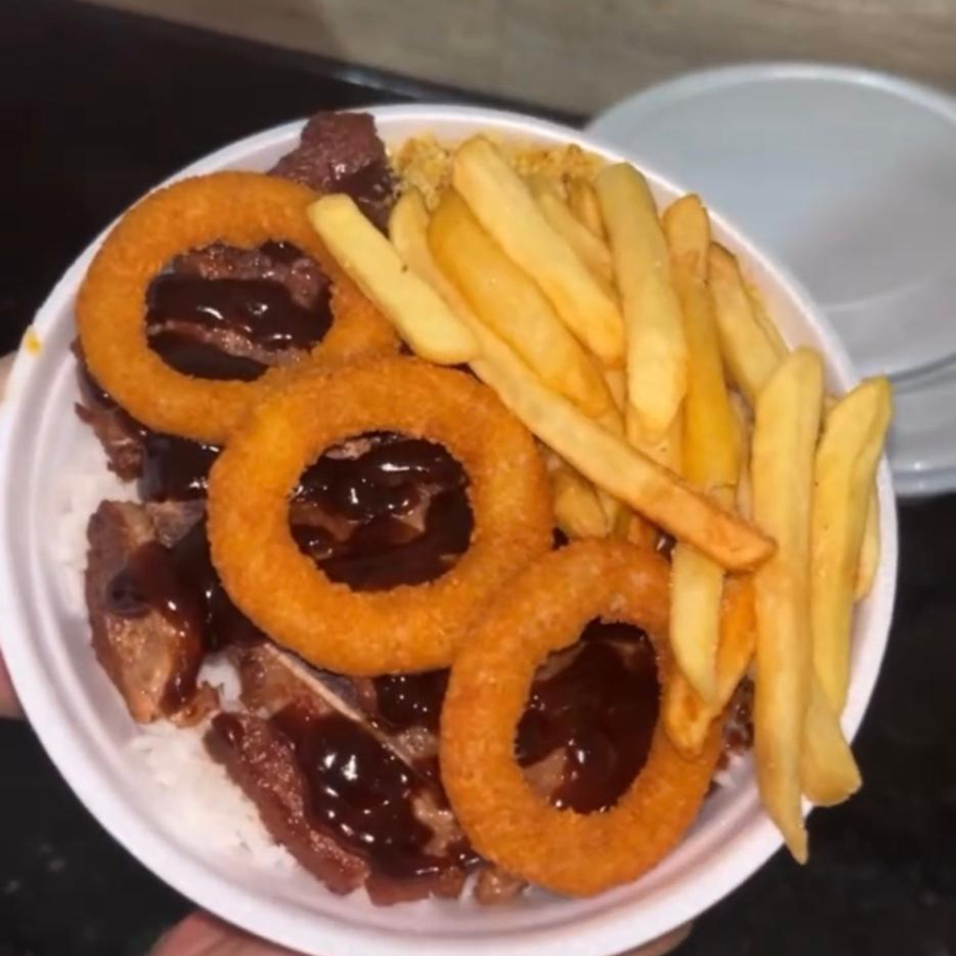 Bisteca suína com molho barbecue e anéis de cebola, acompanha arroz, feijão e 2 acompanhamentos da sua escolha.