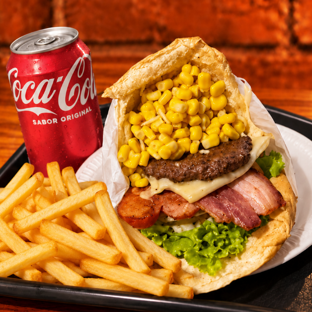 1 X-Tudo (pão, burguer artesanal 60g, queijo, presunto, bacon, ovo, salsicha, milho, batata, abacaxi e salada), acompanhado de batata 150g e 1 Coca-Cola 350ml. Uma combinação caprichada!