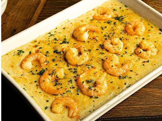 Camarões salteados com cebola, vinho branco e molho cremoso de queijo. Acompanha arroz com passas e batata palha.Tamanho do camarão nesse prato: 18g.