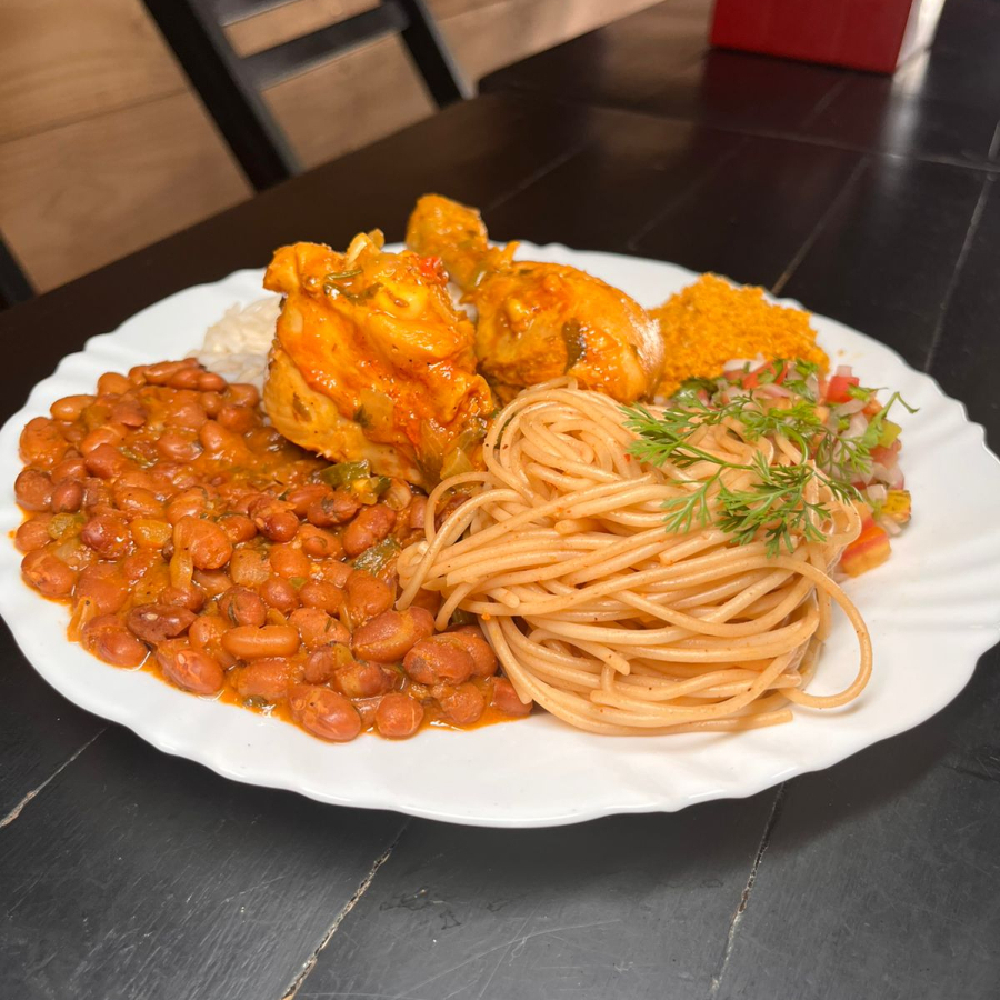 Deliciosa opção de almoço de galinha guisada, acompanhada de arroz soltinho, macarrão, feijão, vinagrete e farofa.