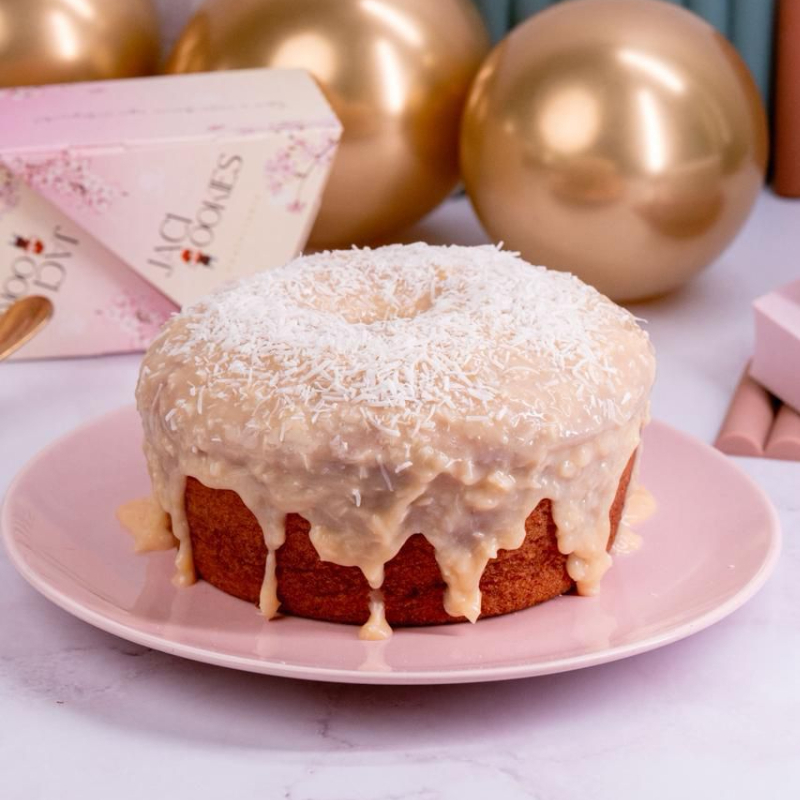 Bolo caseiro de coco com deliciosa cobertura de brigadeiro de beijinho, decorado com raspas de coco ralado.