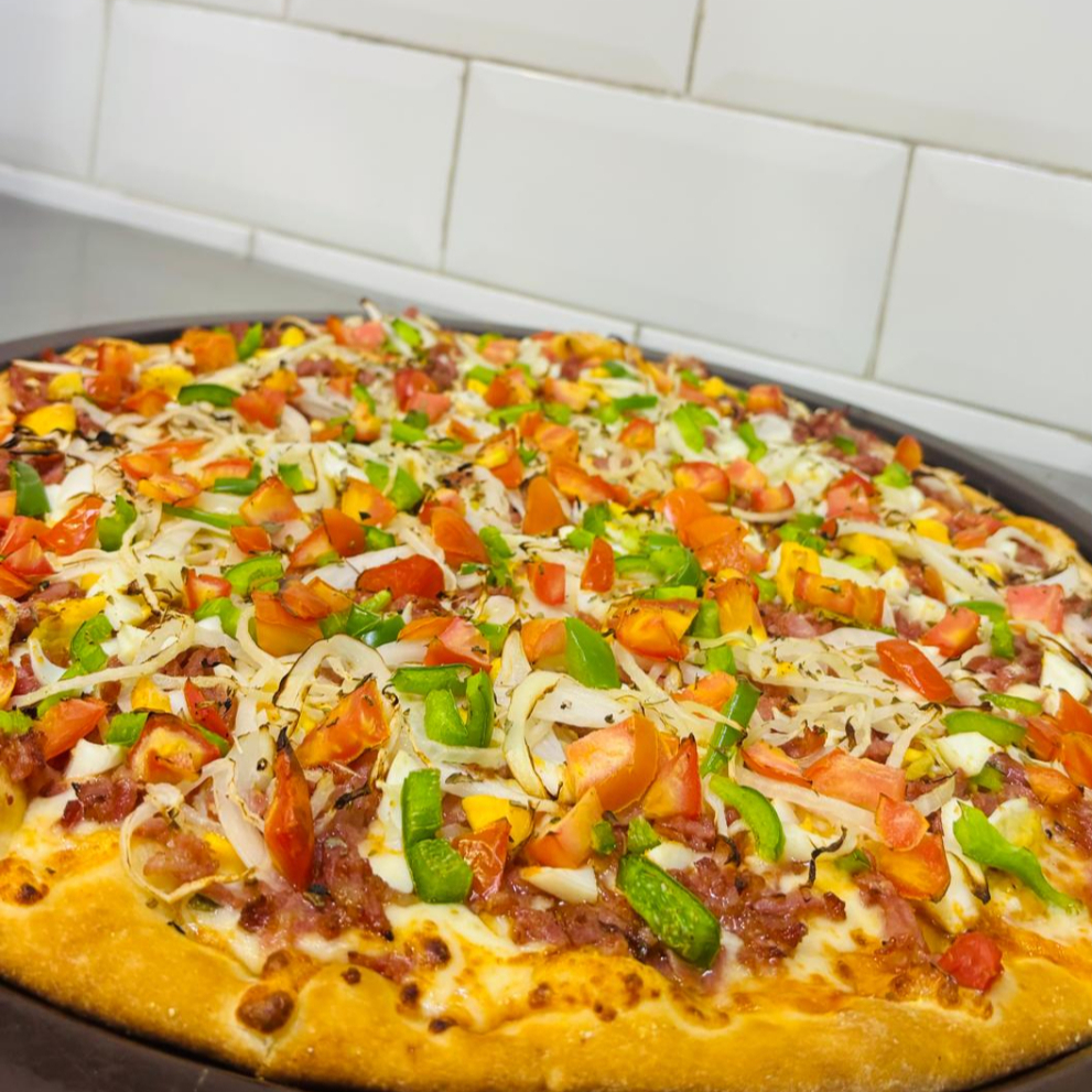 Molho de tomate, queijo muçarela, calabresa ralada, ovo, pimentão, tomate, cebola e finalizada com orégano.