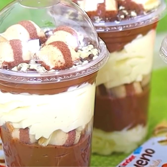 Uma explosão de sabor em camadas irresistíveis para você se deliciar! Cada copo é feito com muito carinho e uma combinação única de ingredientes: brigadeiro de Ninho cremoso, brigadeiro de chocolate delicioso e pedaços de Kinder bueno, Nutella, Creme de Bueno e de brownie de dar água na boca Tags-------------------------- Copo da Felicidade, Sobremesa, Coca-Cola,Combo doce, Doces e Bebidas, Sobremesa gelada, Guloseimas bolo, fatia de bolo, brigadeiro, brigadeiro gourmet, brigadeiro artesanal, Prestígio, chocolate, presente, bolo de fatia., morango, Ninho, bolo de Ninho, cone, cone trufado, cone recheado, ferrero, Kinder, Nutella, coxinha de morango, coxinha chocolate, promoção, petisqueira, doces, mimo.Docinhos, geladinho gourmet, Bolo de chocolate, Bolo de Coco, Brownie recheado, Chocolate, Morango, Brownie, Gourmet, Ganache, Caseiro, Doce de Leite, , Coxinha de Morango, Coxinha de Chocolate, Coxinha Doce, Brigadeirão, Bombom de Morango, Fondue, Coração de Chocolate, Barra Recheada, Cone Recheado,