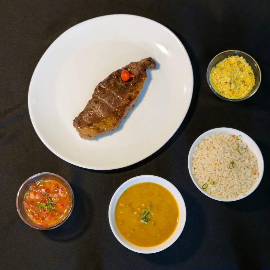 Acompanhamentos: Arroz branco soltinho, feijão, vinagrete, farofa e acompanhamento especial do dia