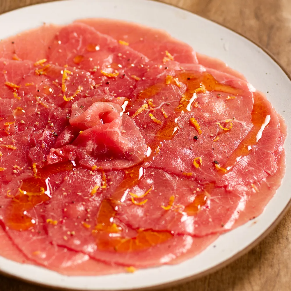 Aprecie o carpaccio, finas lâminas de peixe ao molho do chefe, uma entrada sofisticada e saborosa.