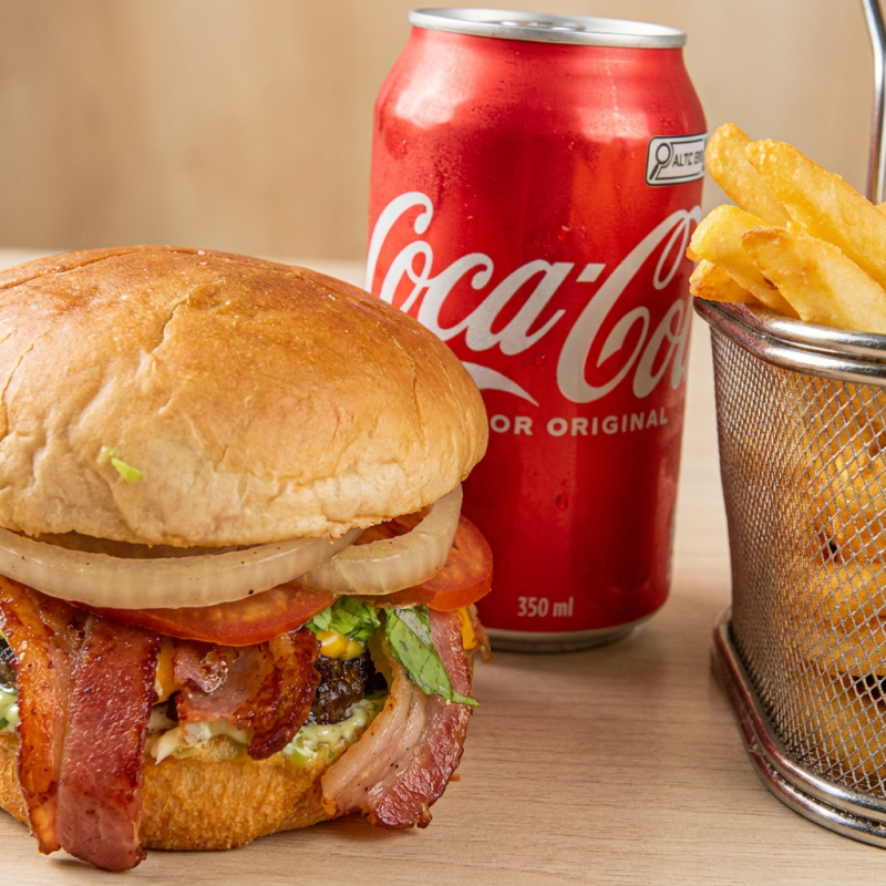 Hambúrguer artesanal com um suculento smash de 100g, com fatias crocantes de Bacon, coberto com queijo cheddar derretido em um pão selado à perfeição. Acompanha uma refrescante salada de tomate, cebola e alface americana. O toque especial fica por conta do molho barbecue e da maionese verde. Para completar, uma porção de 200g de batatas fritas crocantes e uma lata de Coca-Cola de 350ml, complementam essa experiência gastronômica inigualável.