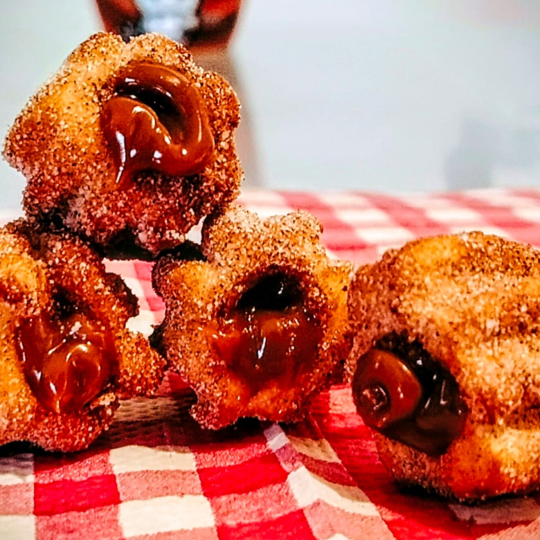 Deliciosos mini churros crocantes, recheados com doce de leite e polvilhados no açucar e canela.