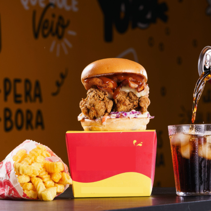 Fabuloso Lanche York preparado no pão Brioche, com melhor Frango Frito Crocante, Salada Coleslaw, Queijo, Bacon e Cebola Empanada. Acompanha Batata Frita Individual + Refrigerante Lata. Foto ilustrativa.