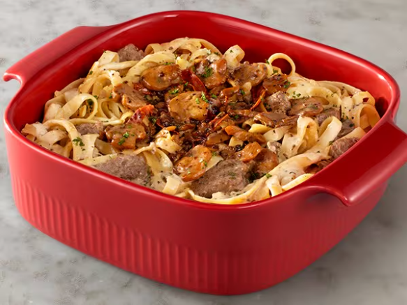 Fettuccine Alfredo com tiras de filet mignon ao nosso molho à base de vinho marsala, com um toque de prosciutto e cogumelos.