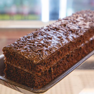 Bolo de chocolate macio e fofinho, coberto com uma generosa camada de chocolate cremoso e granulado.